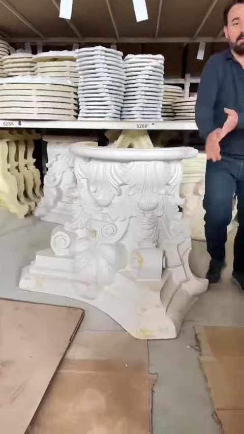 Ornate decorative capitals and carved architectural details sit on shelves