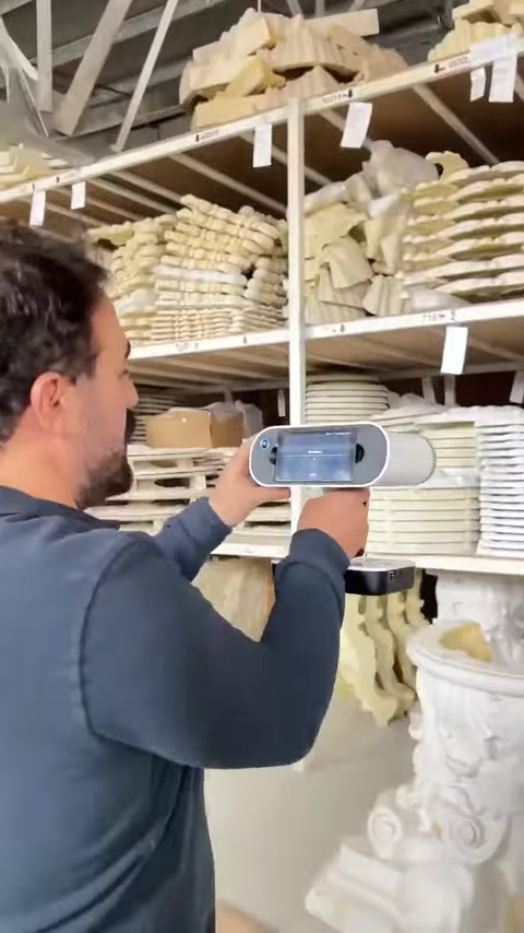 Operator scans a large carved architectural element in the warehouse