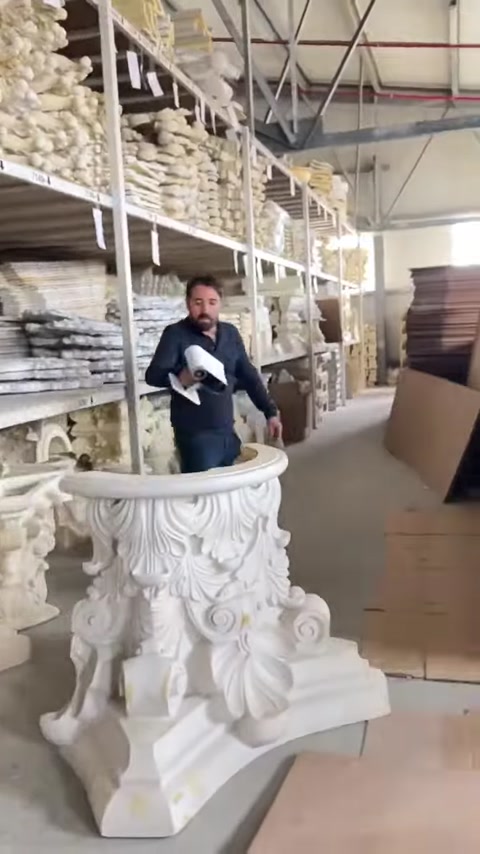 Worker presents a richly detailed decorative column capital