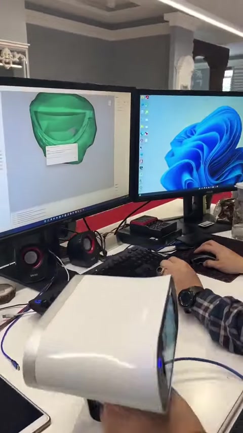 Computer monitor displays a green scanned surface alongside digital modeling