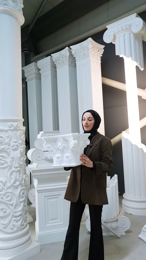 Presenter rotates the white plaster-like decoration piece in his hand
