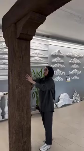 Il presentatore mostra da vicino la superficie verticale effetto tronco con texture del legno