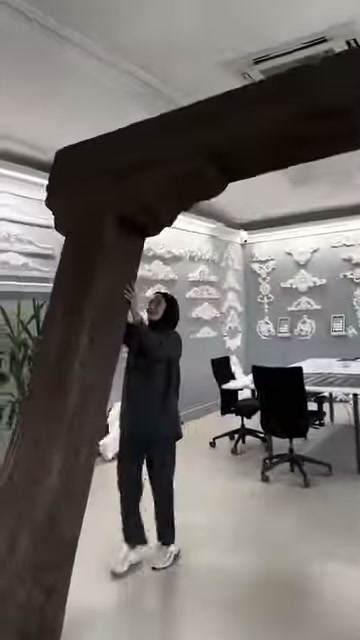 L'incaricato indica la parte superiore della cornice in legno decorativa con la mano