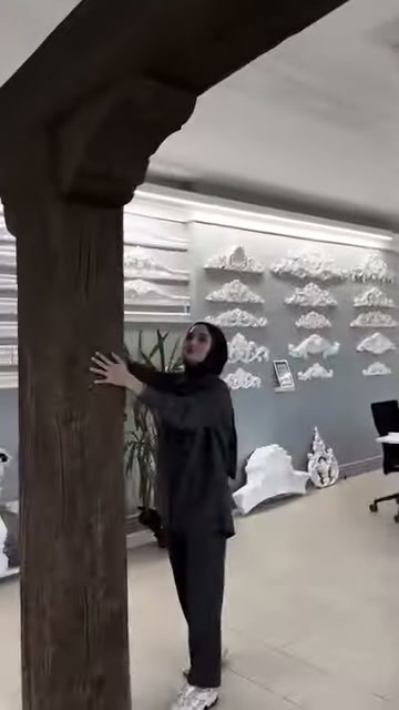 Le venature longitudinali del pilastro in legno sono evidenti nell'ambiente showroom
