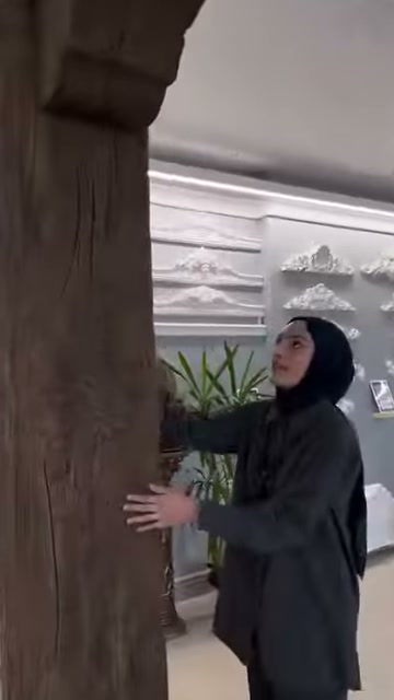 L'incaricato mostra il rivestimento di superficie del pilastro decorativo spesso con la mano