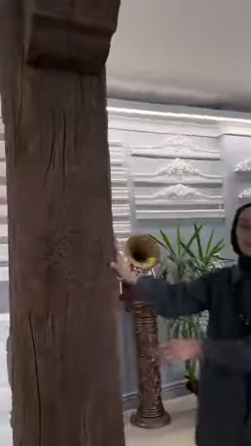 Il modello di pilastro verticale è esaminato davanti ai prodotti decorativi da parete in showroom