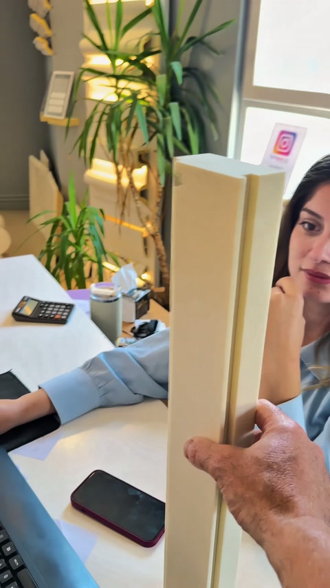 Long decorative profiles examined vertically in front of a worker
