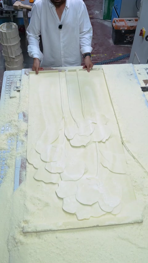 Viene esaminata la superficie lavorata di un pannello con motivo floreale su una macchina CNC