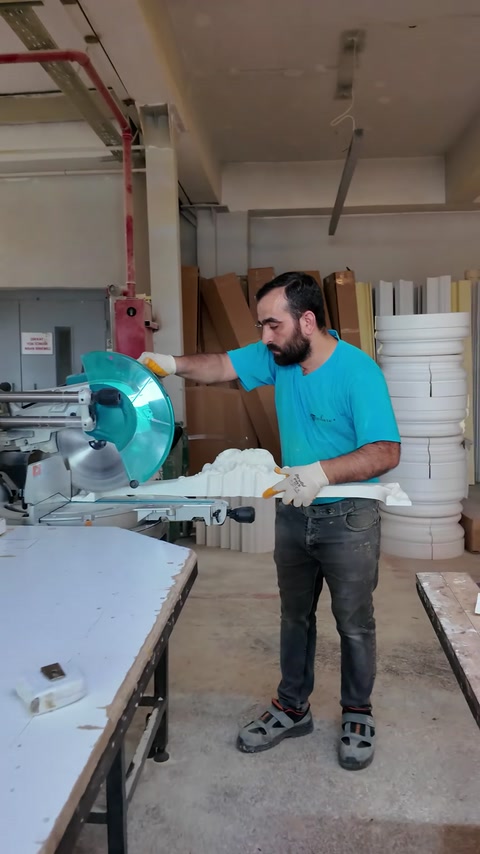 Ornate fireplace trim is cut to length with a miter saw.