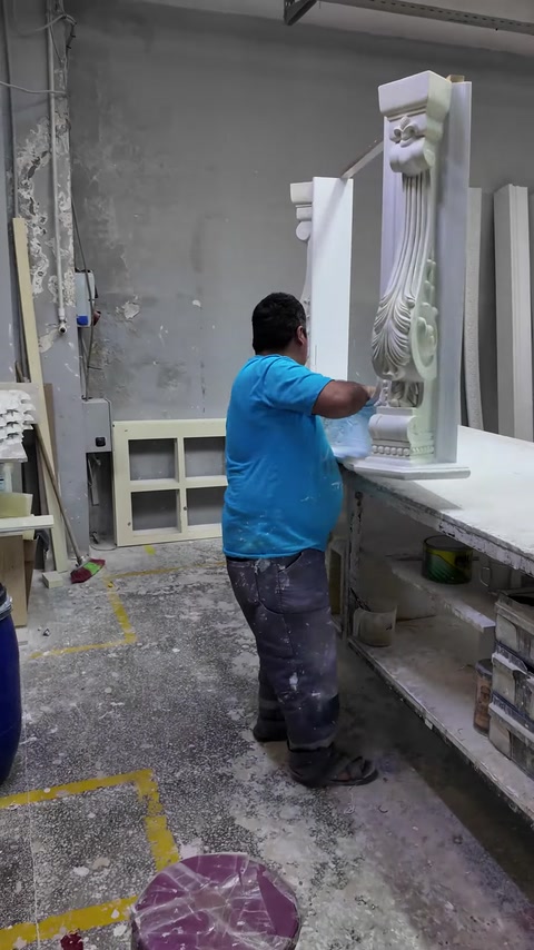Worker applies a finishing coat to an upright decorative pilaster.