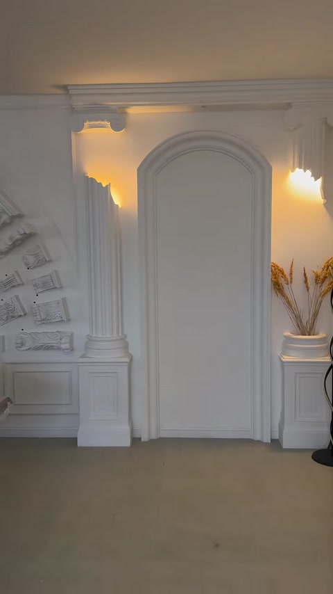 Nicchia ad arco illuminata circondata da colonne e pannelli murali