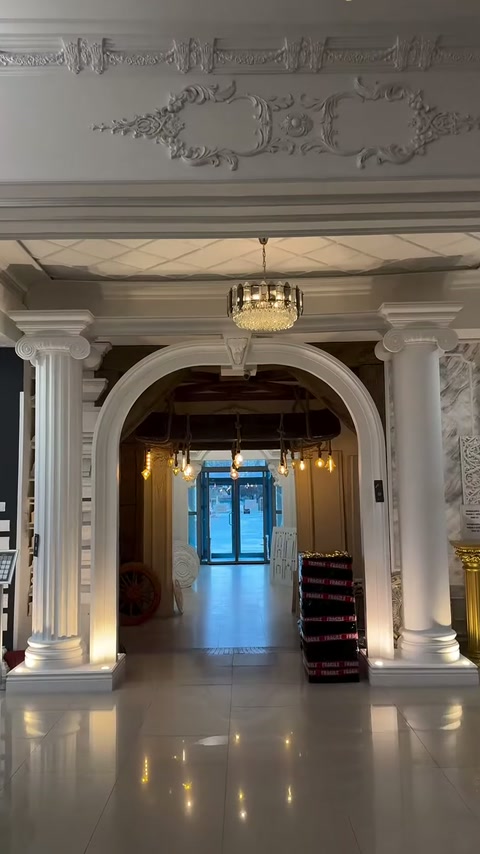 Corridoio d'ingresso con arco, colonne scanalate e soffitto decorato