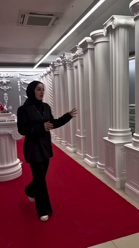 Tanıtıcı, duvar boyunca sıralanan uzun sütunları karşıdan gösteriyor.