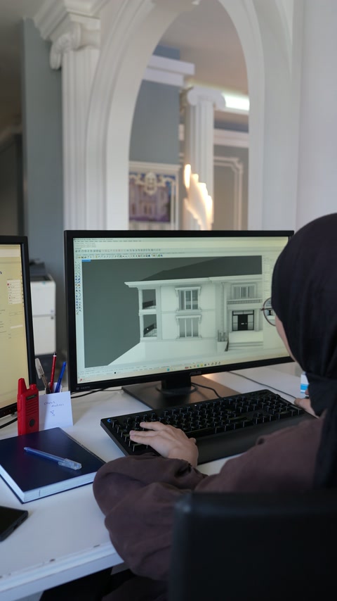 Tasarımcı, sütunlu villa cephesinin dijital modelini bilgisayarda inceliyor.