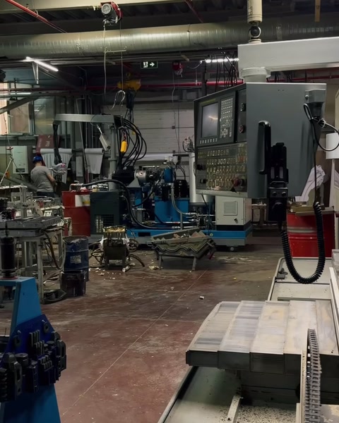 Un'ampia area di lavoro con macchinari e carroponte lungo la linea di produzione