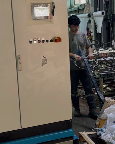 Un operaio si prepara alla produzione davanti al pannello di controllo della macchina dosatrice