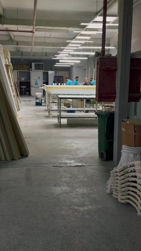 Un ampio reparto produttivo con lunghi banchi da lavoro