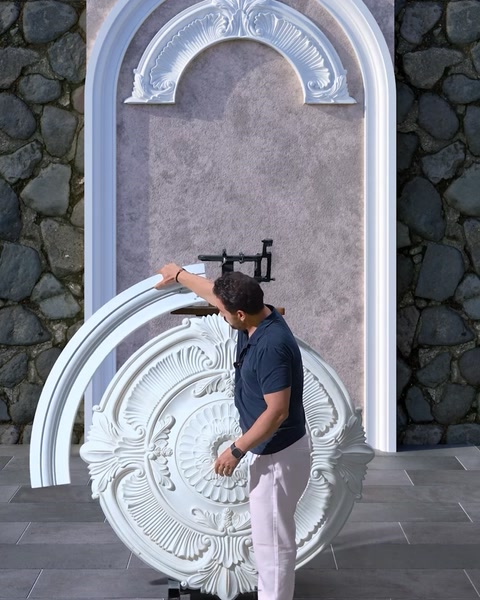 Operaio che attacca un pezzo ad arco curvo al modello di parete decorativa