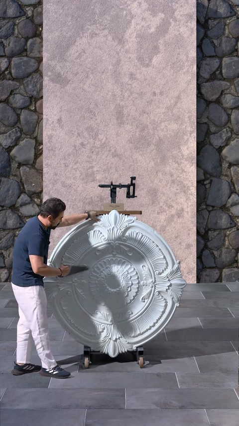 Worker cutting center section out of ceiling medallion piece