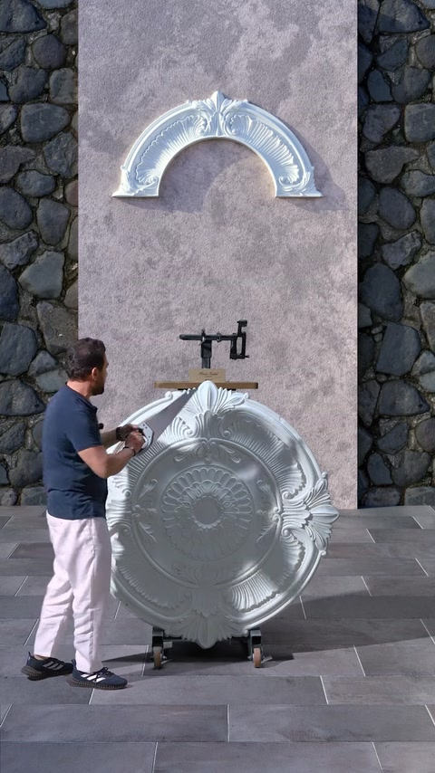 Man holding cut medallion revealing two matching arch pieces
