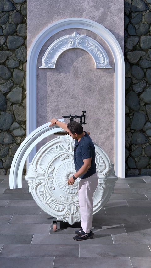 Worker attaching curved arch piece to decorative wall mockup