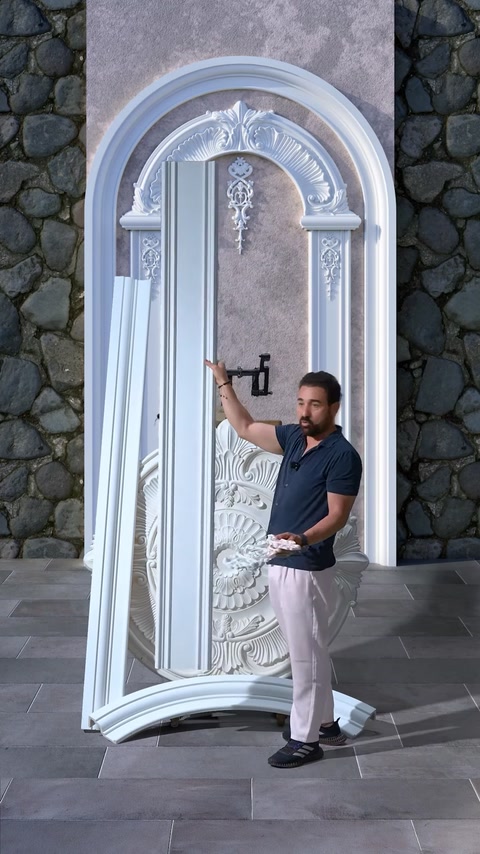 Man installing ornament detail on completed archway wall design