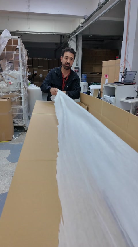 Long white profiles are placed in a cardboard box with protective packaging