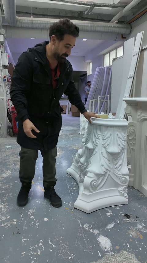 Il maestro illustra i dettagli di produzione accanto al capitello completato.