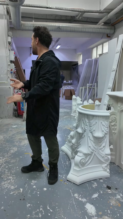 Il capitello corinzio bianco è esposto da diverse angolazioni sul pavimento dell'officina.