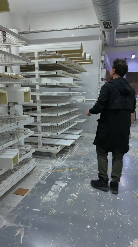 Sugli scaffali dell'officina si trovano vari elementi decorativi in poliuretano bianco.