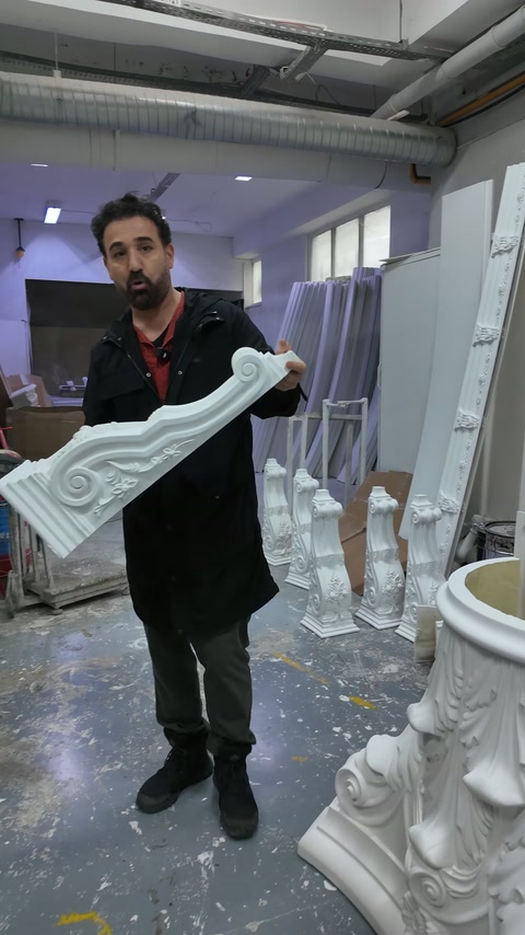 La lunga cornice curvata è esposta orizzontalmente nell'officina.