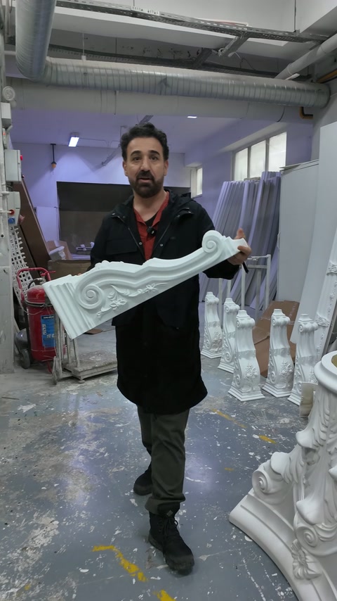 Il maestro tiene la cornice con rilievo all'altezza del busto.