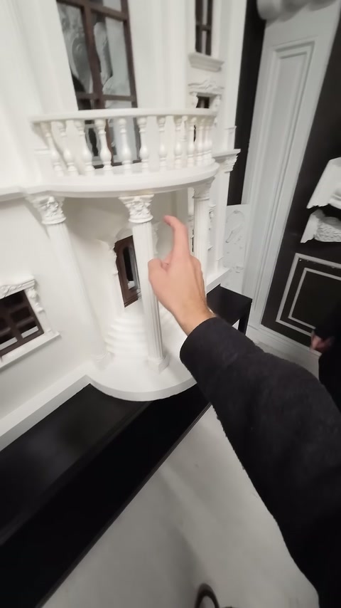 El, maketteki üst balkon korkuluğunu ve cephe düzenini işaret ediyor.