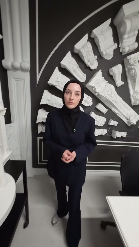 Sunucu, payanda örnekleri önünde showroom ürünleri hakkında bilgi veriyor.