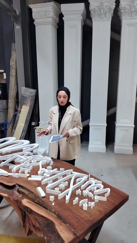 Parti di logo bianco sono esaminate sul tavolo davanti agli esempi di cornice.