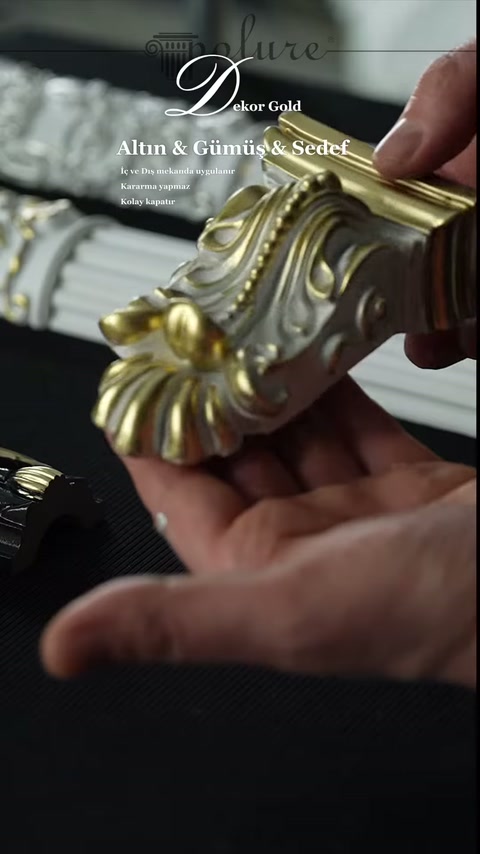 Metalik tonlarla boyanmış mini sütun başlığı elde yakından gösteriliyor