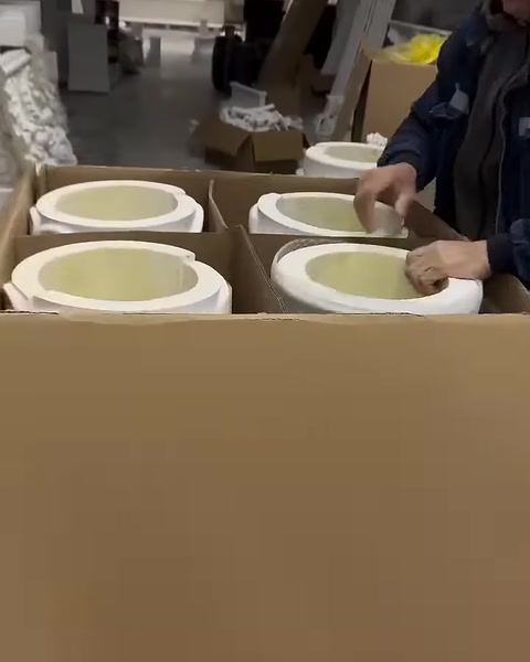 Circular decorative pieces are neatly arranged inside a shipping box