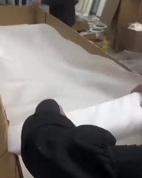 A white protective sheet is spread over the profiles in the box