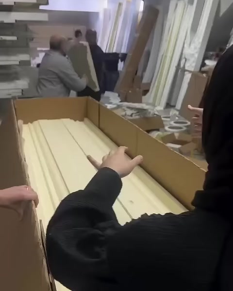 Yellow protective pieces are arranged between the profiles in an open box