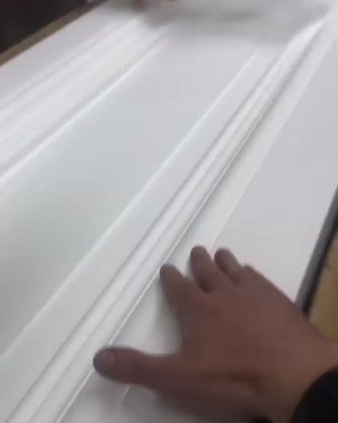 A white decorative molding with a stepped surface is examined