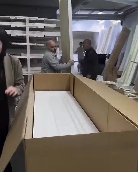 White decorative profiles are packaged inside an open shipping box