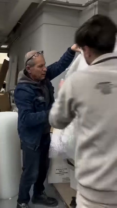 Workers adjusting the packaging of a standing decorative column together
