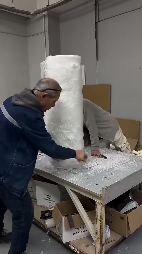 Bottom edge of protective cover being sealed while wrapping the column body