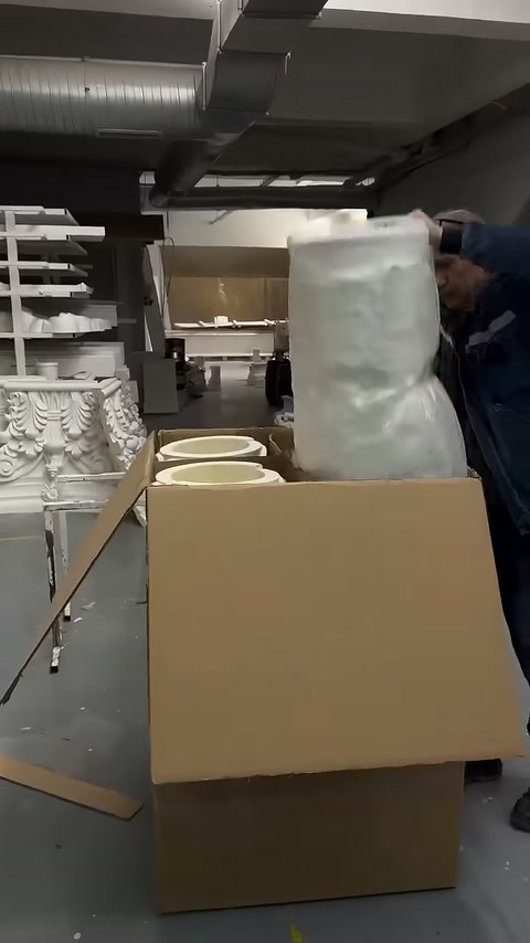 Column body covered with protective wrap being placed vertically in the box