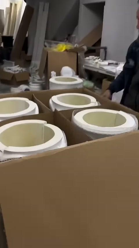 Circular decorative pieces visible inside partitioned cardboard packaging