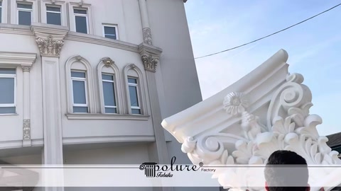 Multi-storey building façade behind an ornamental column capital