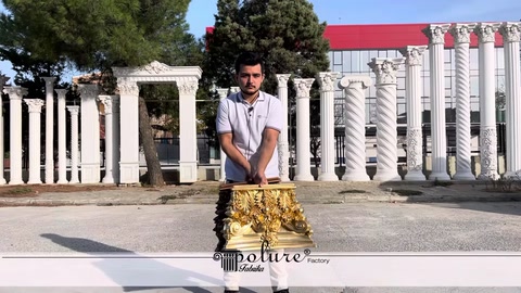 A staff member presenting a gold ornamental column capital