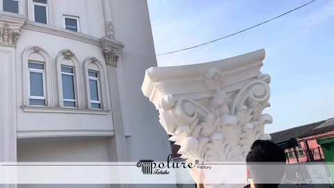 Capitello per colonna con motivo classico presentato davanti alla facciata di un edificio