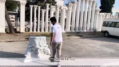White decorative column capital being lifted from the ground by a staff member