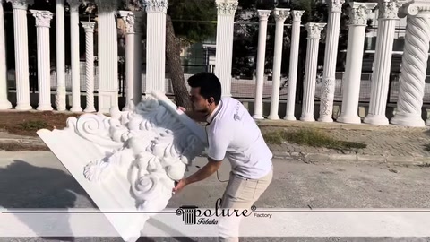 White column capital being raised to highlight its carved detailing